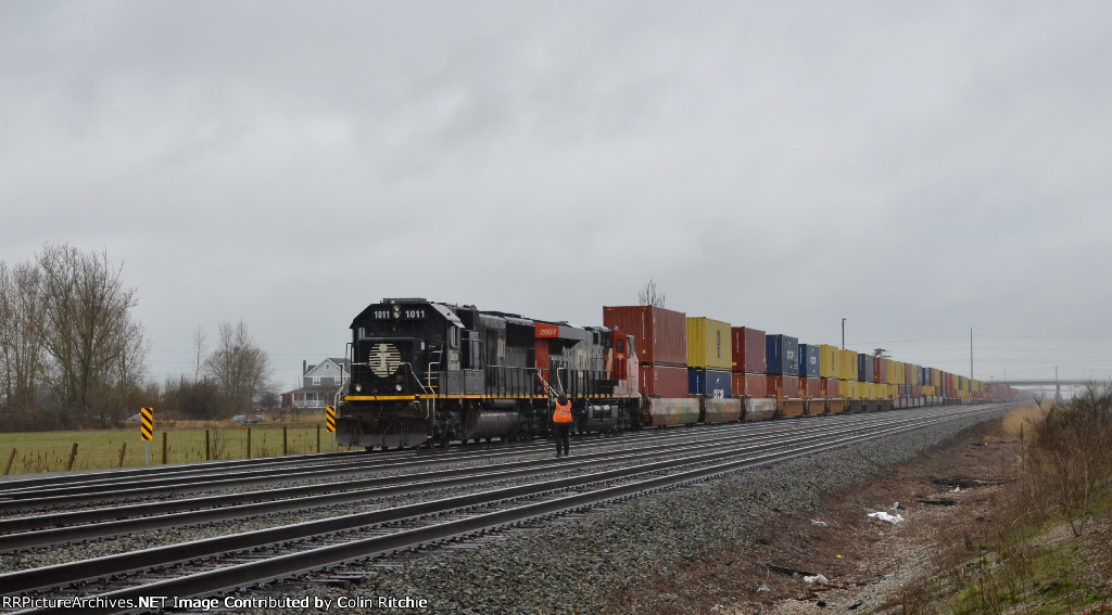 Fresh crew change in Fisher Siding, with conductor of IC 1011 taking a moment to take a pic of the unit stack train to be E/B to Chicago from Robert's Bank.